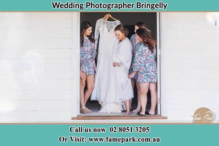 Photo of the Bride with her bridesmaids checking her gown Bringelly NSW 2556