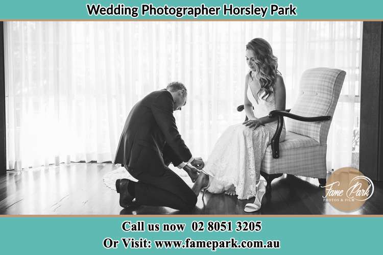 The Bride is being helped by the Groom trying to put on her shoes Horsley Park NSW 2175